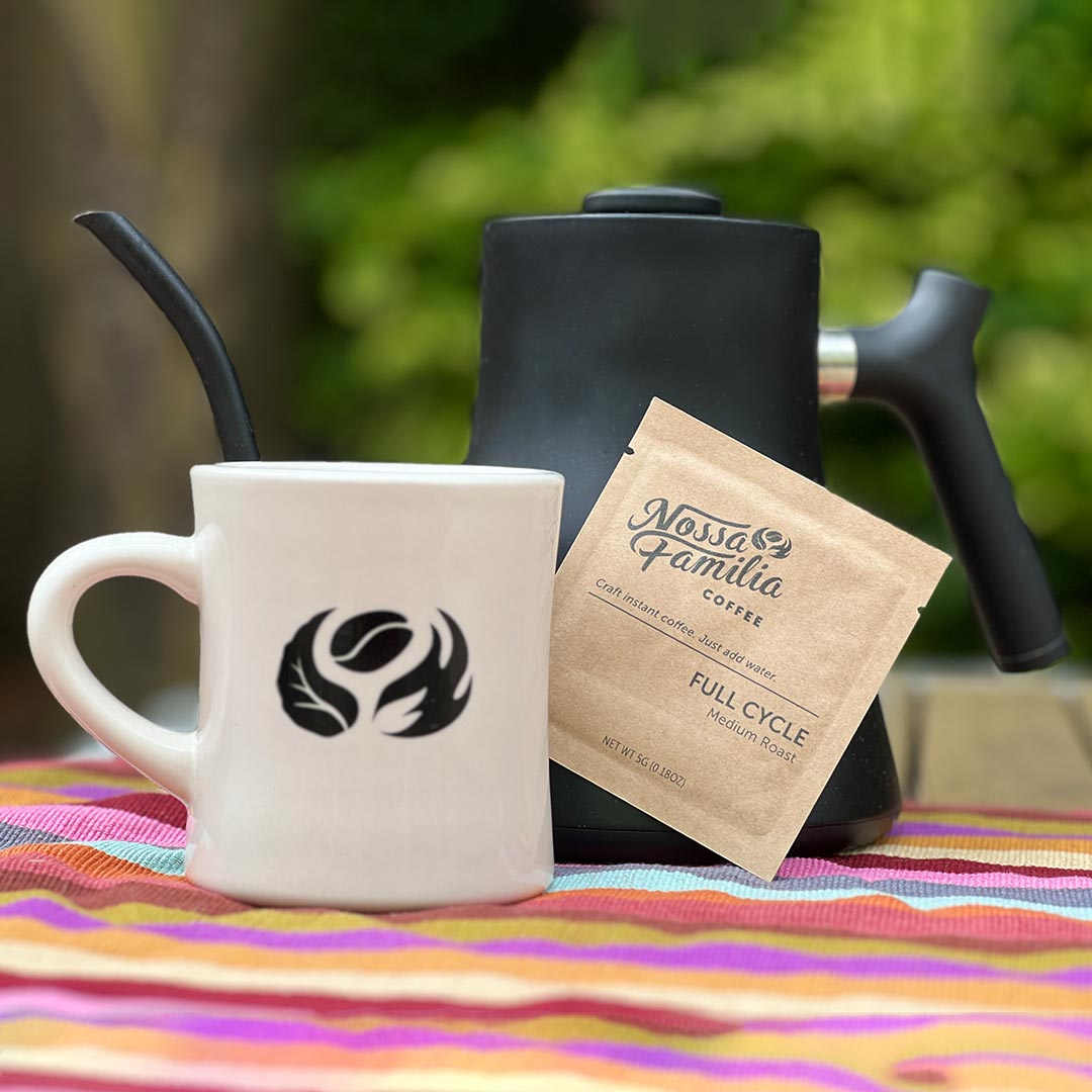 Nossa Familia Instant Coffee sachet being poured into a cup